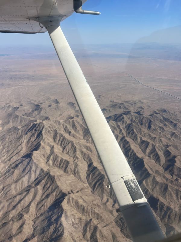student takes flying lessons flying over san diego dessert